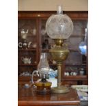 A brass oil lamp with floral etched shade to/w a small smoked glass oil lamp