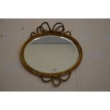 An oval gilt-framed wall mirror