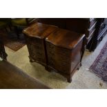 A pair of reproduction mahogany serpentine front bedside chests