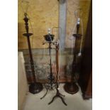 Three turned mahogany standard lamps to/w a Victorian wrought iron standard lamp