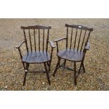 A pair of Ercol style elm spindle back carver chairs