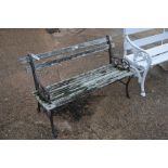A weathered Victorian style cast metal and weathered slatted teak garden bench