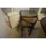 A nest of three carved mahogany tables and laundry basket