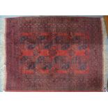 An Afghan rug, the red-brown ground with red two rows guls