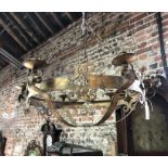 A large circular gilt metal six sconce hanging chandelier in the medieval style