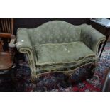An antique hump back serpentine form sofa with scroll arms