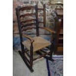 An 18th century oak ladder back rocking armchair