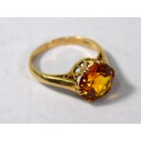 A single stone ring set with circular claw-set orange citrine