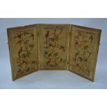 An antique giltwood framed triptych silk embroidered three panel folding screen