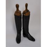 A pair of 1920s lady's black leather riding boots and wooden boot trees