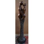 A brown bronze figural sculpture of a kissing couple