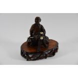 A Japanese Meiji period (1868-1912) carved hardwood okimono of a fisherman