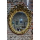 A large giltwood and composite framed oval mirror
