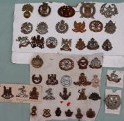 A collection of circa forty two military cap badges including The Royal Warwickshire,