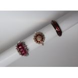 A ruby and diamond cluster ring, set with a cluster of round brilliant cut diamonds,