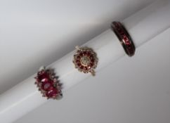 A ruby and diamond cluster ring, set with a cluster of round brilliant cut diamonds,