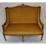 A French gilt decorated two seater settee, with a gilt leaf moulded scrolling back,