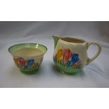 A Clarice Cliff milk jug and sugar bowl, decorated in the Crocus pattern with a green border,