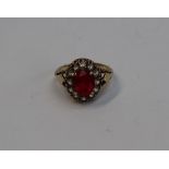 A ruby and white spinel cluster ring, the central oval ruby approximately 9mm x 7mm,