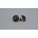 A pair of diamond cluster earrings, set with a central old round cut diamond approximately 0.
