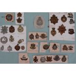 A collection of circa thirty five military cap badges including The Royal Highlanders Black Watch,
