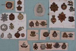 A collection of circa thirty five military cap badges including The Royal Highlanders Black Watch,