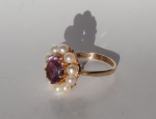 An amethyst and pearl ring, the central oval faceted amethyst approximately 10 x 8mm,