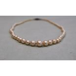 A pearl necklace, set with ninety five individually knotted pearls to a paste set clasp, 50cm long,