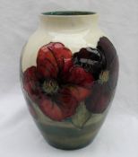 A Moorcroft Clematis pattern vase with a tapering neck to a cream ground, impressed mark,