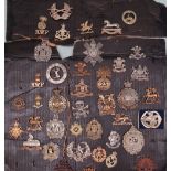 A collection of circa forty military cap badges including Royal Welsh Fusiliers,