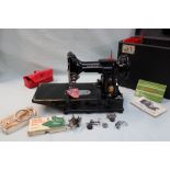 A Singer Model 222K featherweight convertible portable sewing machine, cased together with bobbins,