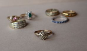 A diamond cluster ring together with six gem set rings