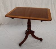 A George III mahogany tripod table with a crossbanded top on a snap action and baluster column with