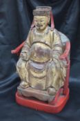 A Chinese carved, gilt and red painted figure of a seated dignitary,