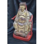 A Chinese carved, gilt and red painted figure of a seated dignitary,