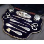 A George V silver manicure set, comprising nail buff, scissors, pots and covers etc, cased,