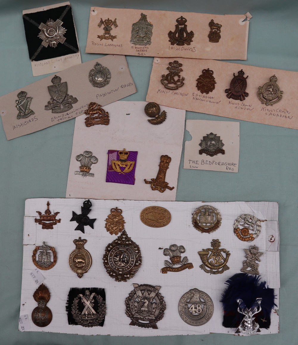 A collection of circa thirty five military cap badges including Highland Light Infantry,