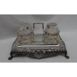 A late Victorian silver desk standish, with a shell leaf and dart border on four claw feet,