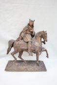 A bronze model of a king on horseback, with a sword in his left hand and right hand open,