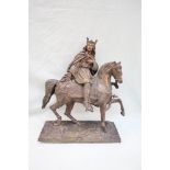 A bronze model of a king on horseback, with a sword in his left hand and right hand open,