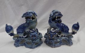 A pair of continental maiolica lion dogs, with foot raised on a ball, with a pierced base,