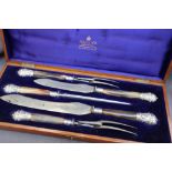 A late Victorian silver mounted and horn handled carving set, comprising two knives,