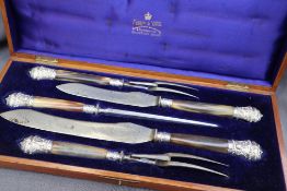 A late Victorian silver mounted and horn handled carving set, comprising two knives,