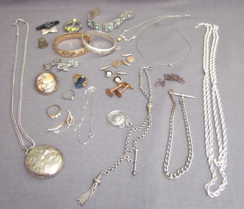 A silver locket on a chain, together with other silver chains,brooches,