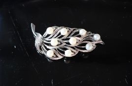 A 14ct white gold brooch in the form of a leaf set with nine pearls each approximately 6mm diameter