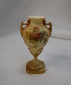 A Royal Worcester porcelain twin handled baluster vase on a spreading foot and square base,