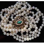 A three strand pearl necklace, set with individually knotted regular pearls each approximately 7mm,