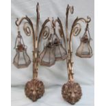 A pair of brass three branch wall sconces, with lion mask heads and scrolling terminals,