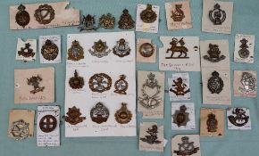 A collection of circa thirty five military cap badges including The Royal Armoured Corps,
