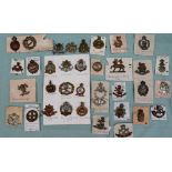 A collection of circa thirty five military cap badges including The Royal Armoured Corps,